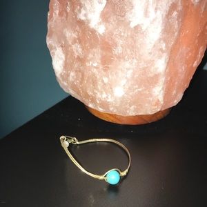 Turquoise stone bracelet with gold wire wrapping.